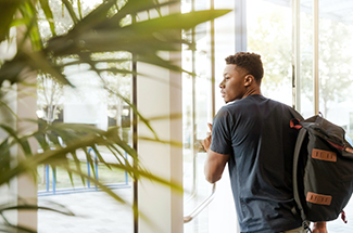 student walking out door